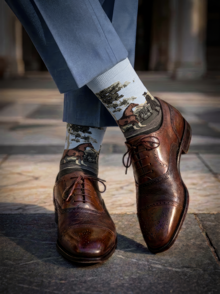 Charcoal grey ArtyGifts socks with pale blue cuffs, worn with blue trousers and brown leather Oxford shoes.

