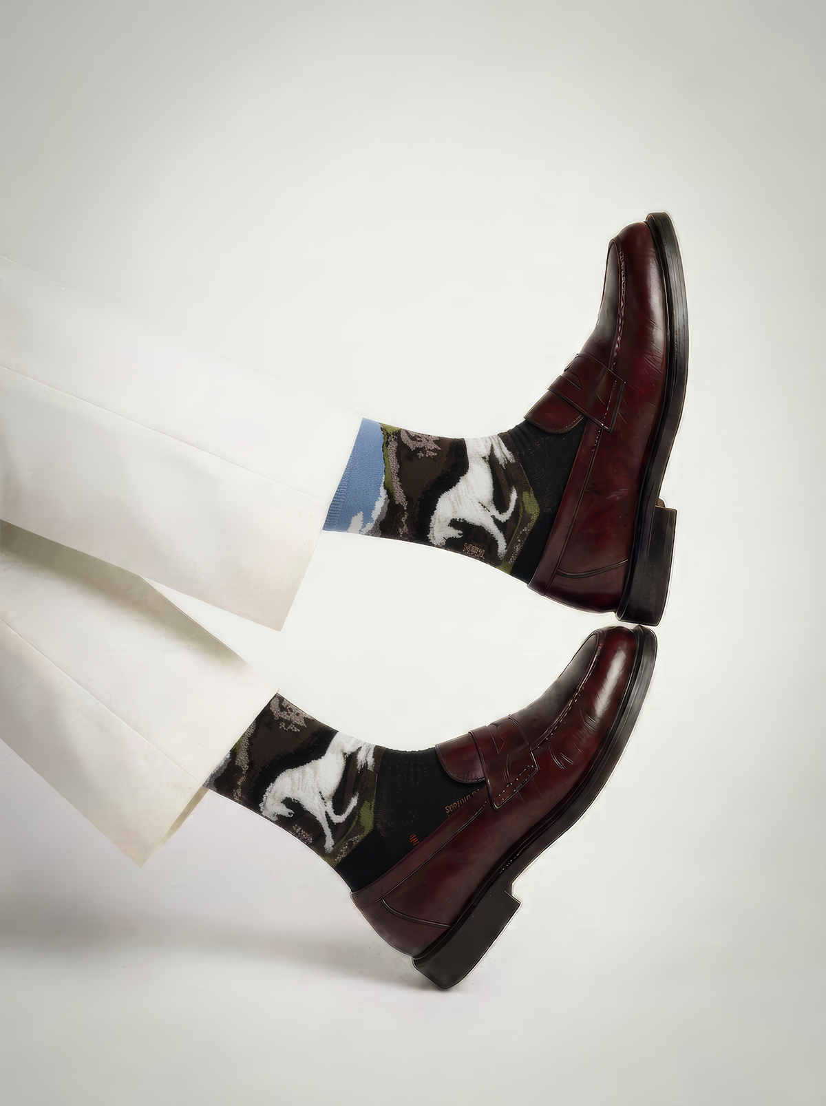 Charcoal ArtyGifts socks with pale blue cuffs and monochrome horse artwork, styled with brown dress shoes against a white background.