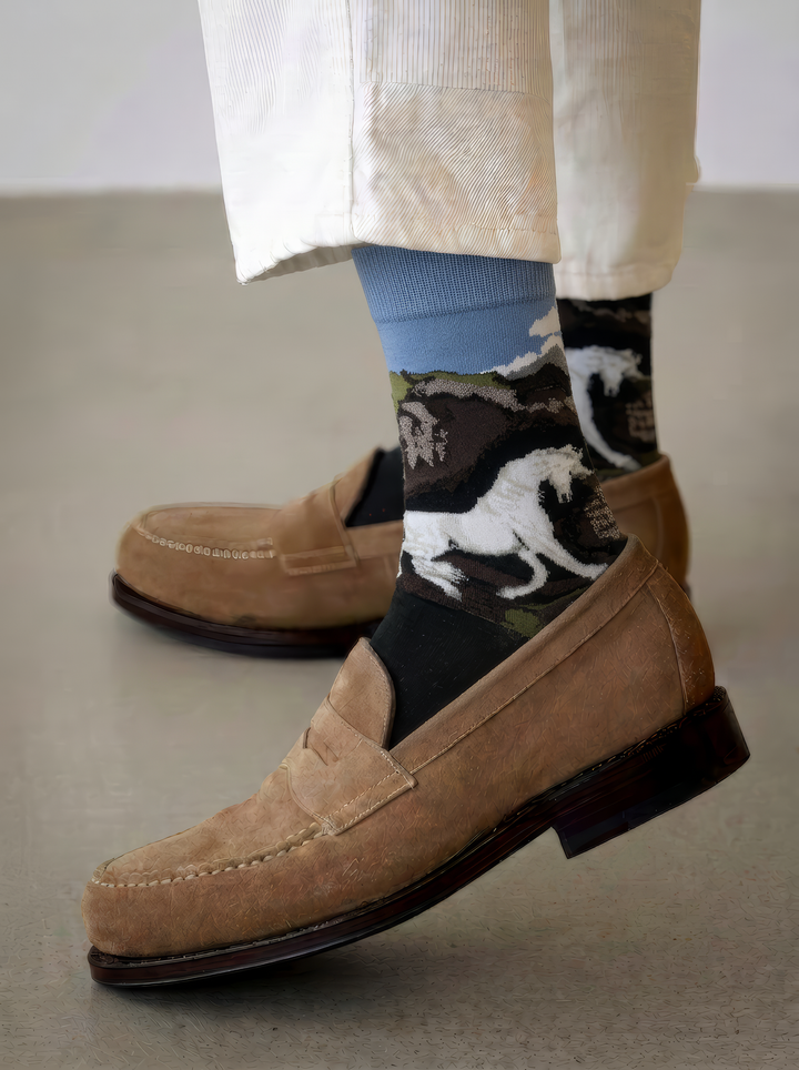 Charcoal ArtyGifts socks with pale blue cuffs and horse artwork, styled with light trousers and tan suede loafers.