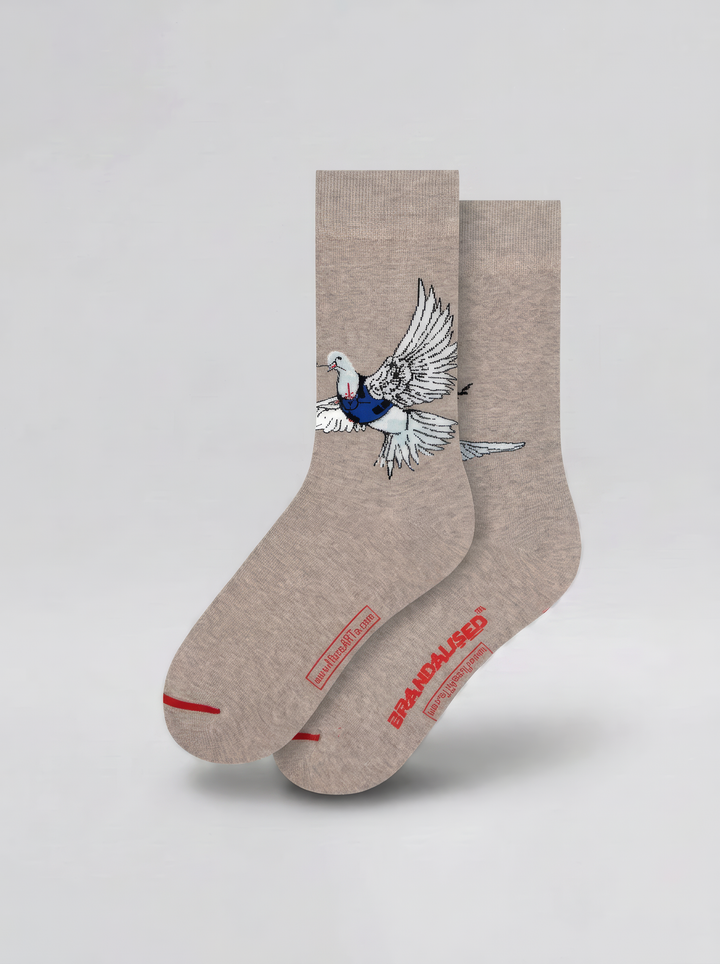 Pair of warm grey Banksy-inspired Peace Dove art socks with a black and white dove motif and red accents, displayed against a pale background.
