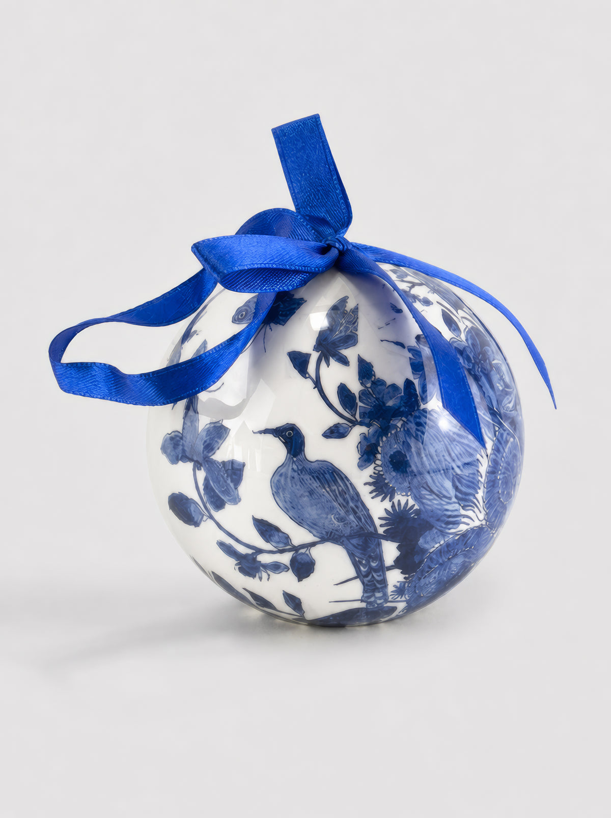 Close-up of a Delft Blue birds and floral design Christmas bauble with cobalt blue ribbon on a light grey background, showing detailed blue and white bird and flower pattern – officially licensed Rijksmuseum collection museum art ornament, 7 cm diameter, unbreakable, in gift box. A unique Dutch heritage Christmas gift from ArtyGifts.

