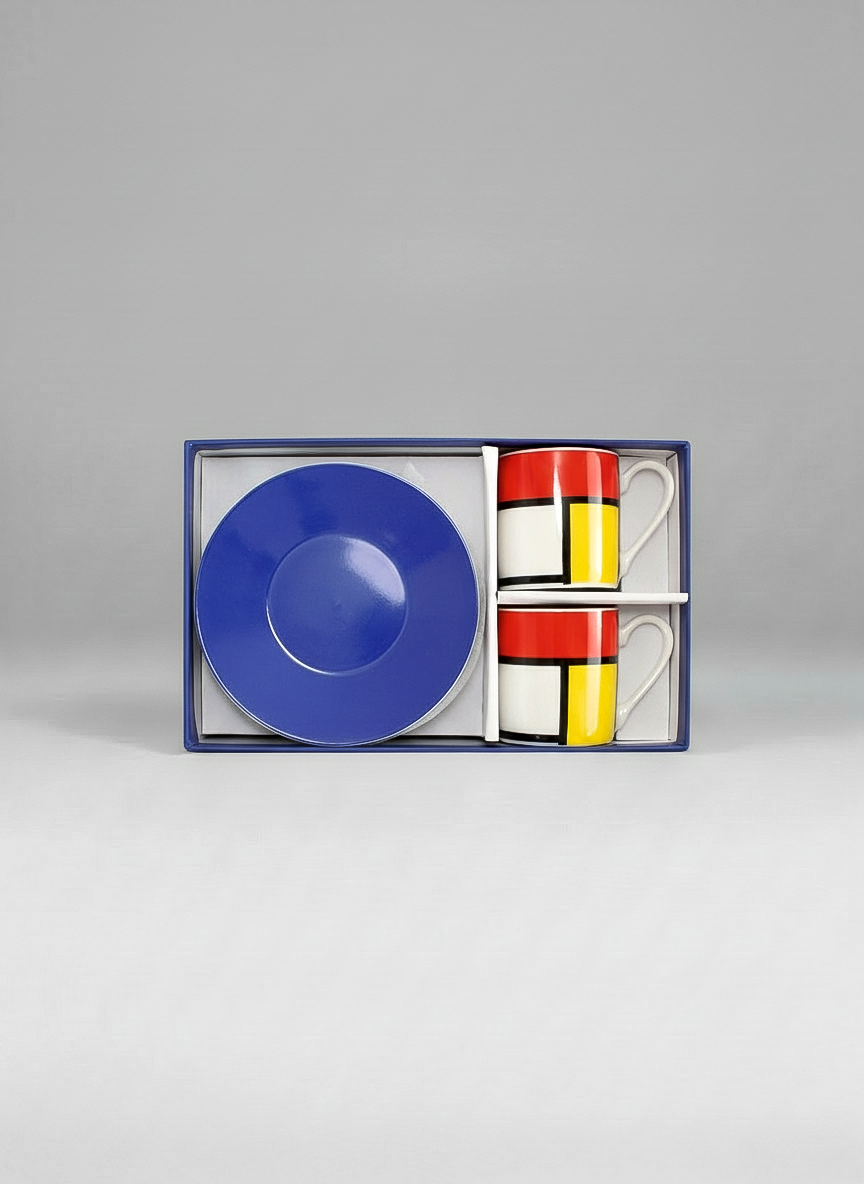 Set of two mugs with Mondrian-style design in a box on a gray background