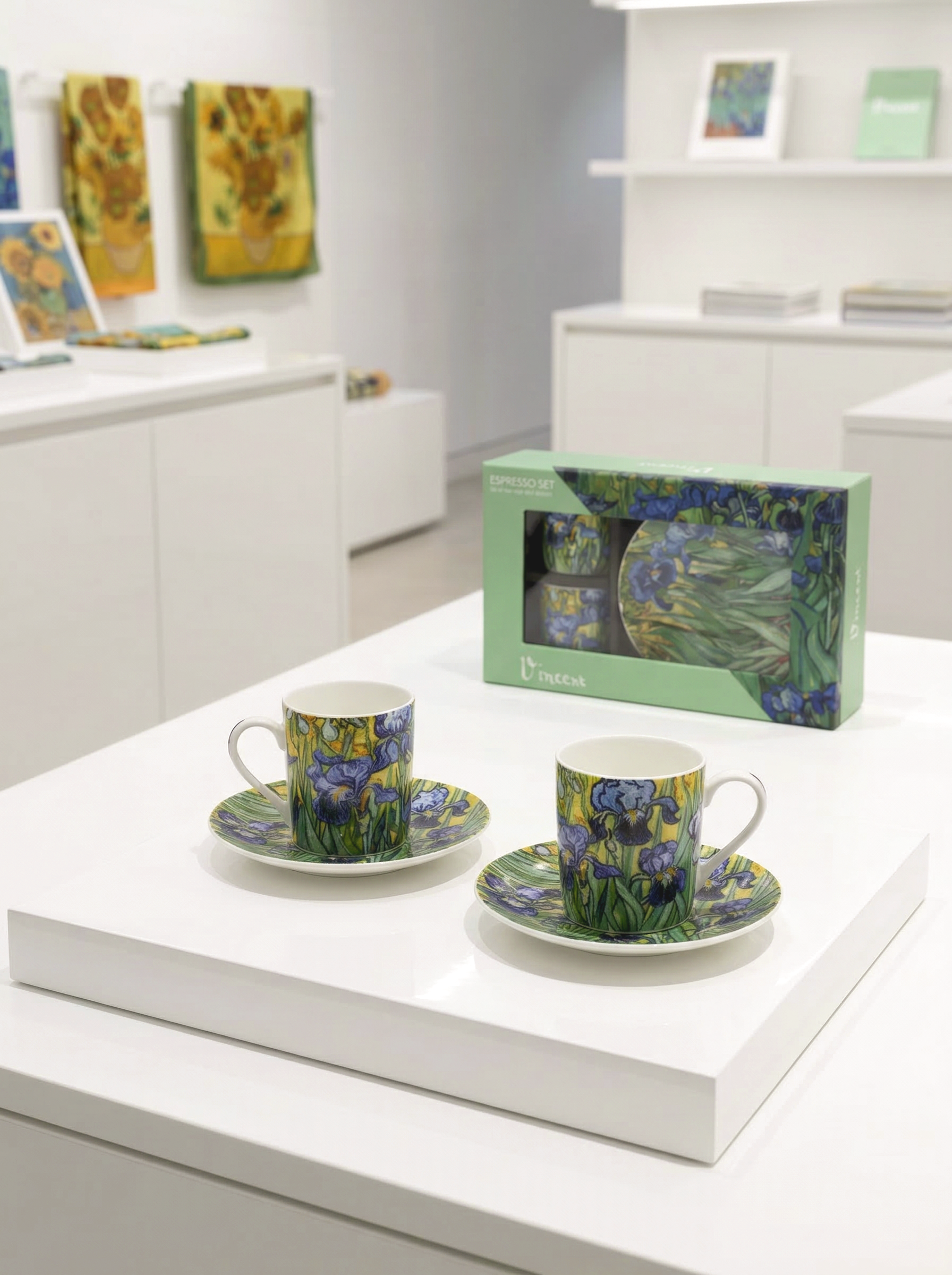Two ceramic cups with saucers and a box on a white surface, with Van Gogh artwork in the background.