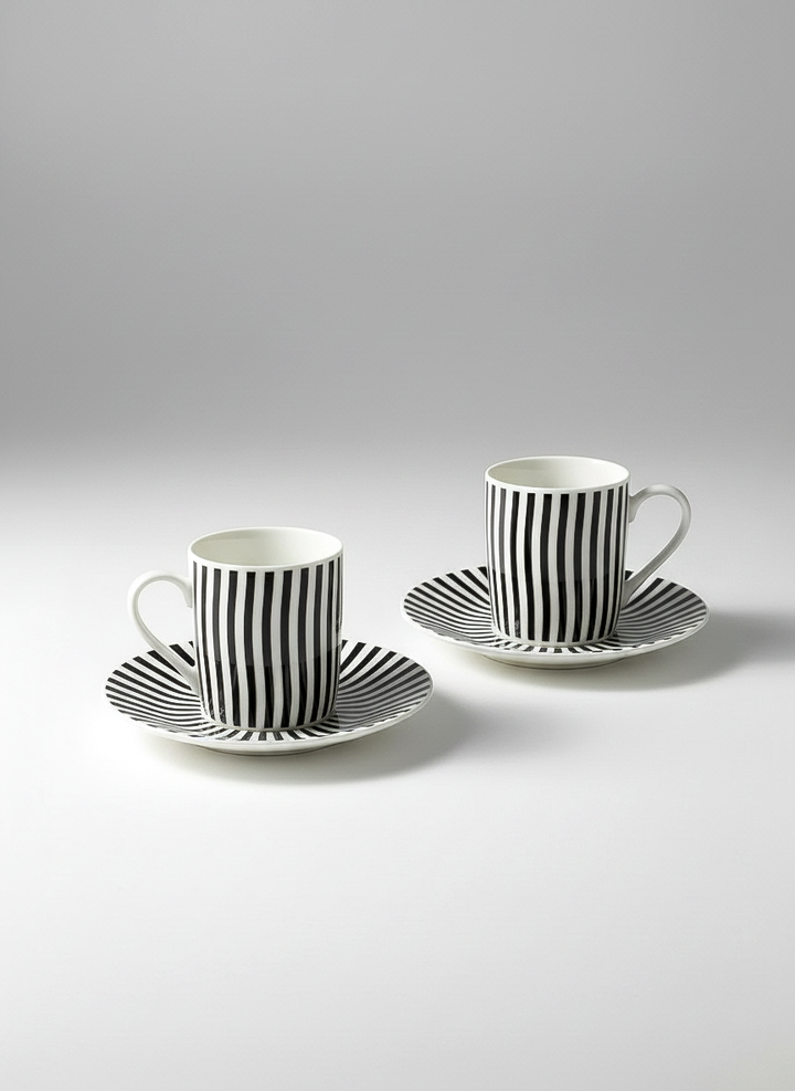 Two black and white striped coffee cups with saucers on a light gray background. Optical Art