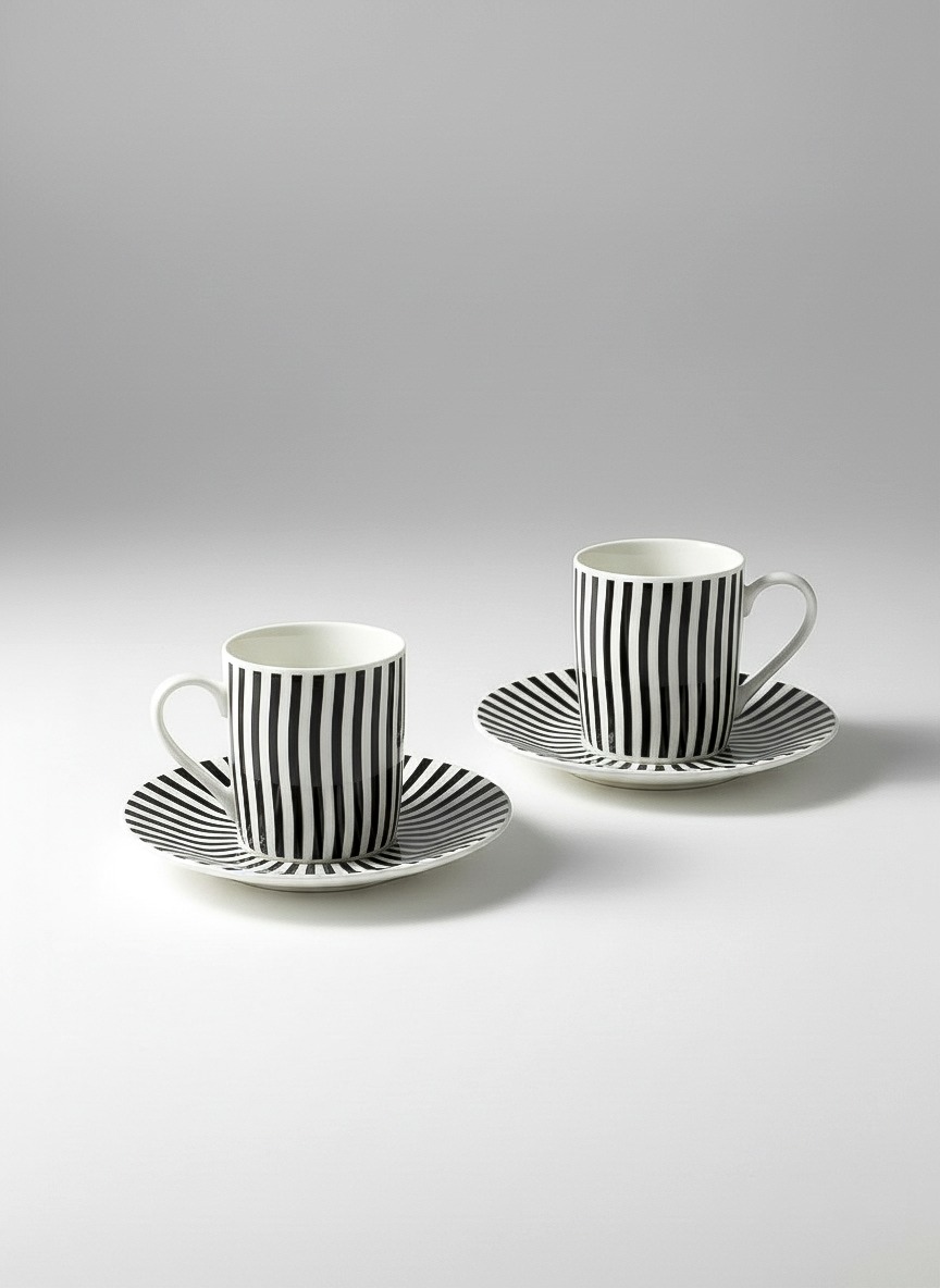Two black and white striped coffee cups with saucers on a light gray background. Optical Art