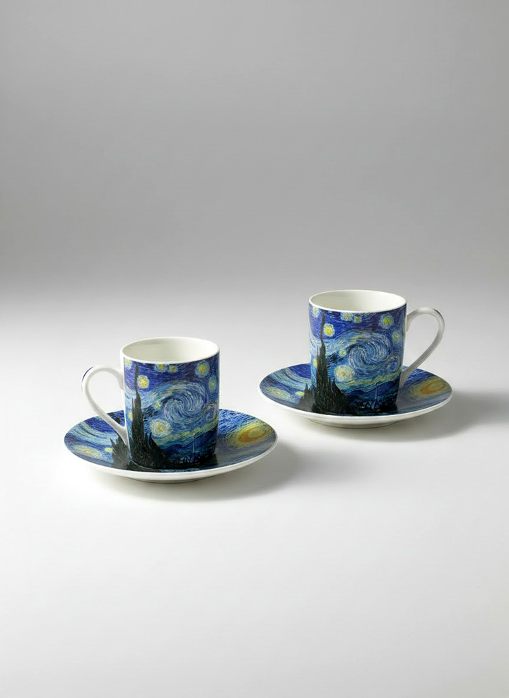 Two coffee cups with saucers featuring Van Gogh's 'Starry Night' design on a gray background.