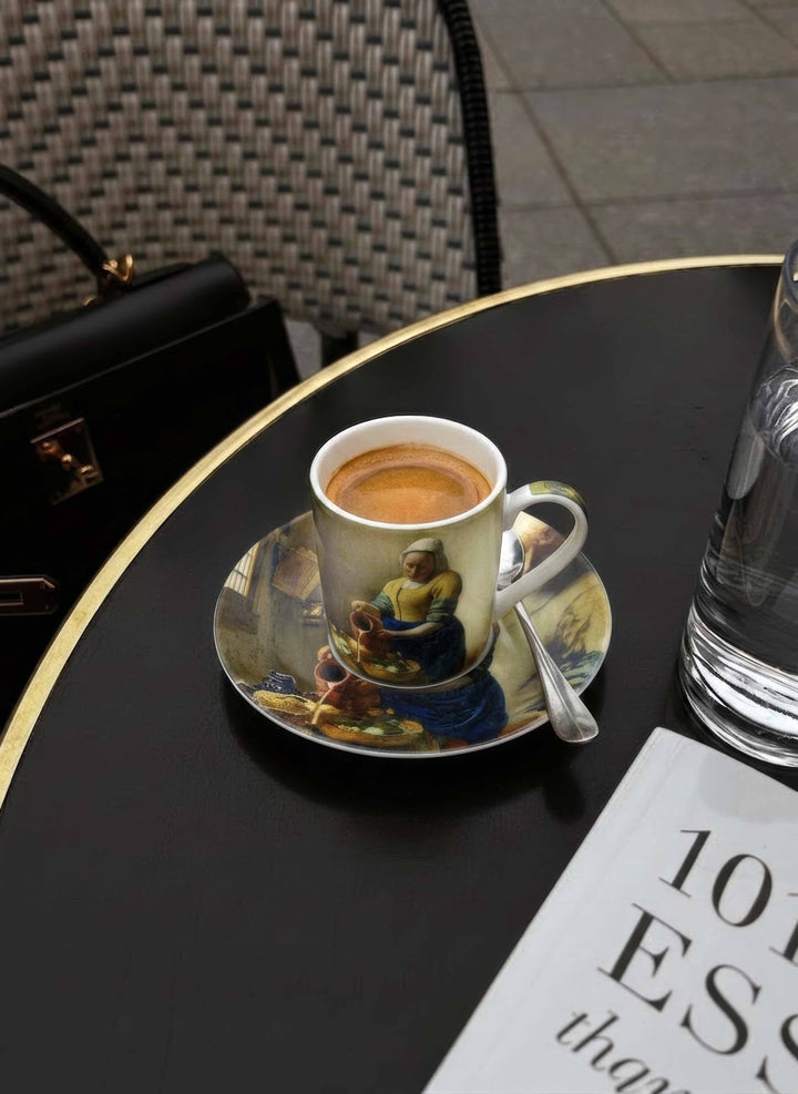 The Milkmaid espresso cup and saucer by Johannes Vermeer on dark table — ArtyGifts museum tableware

