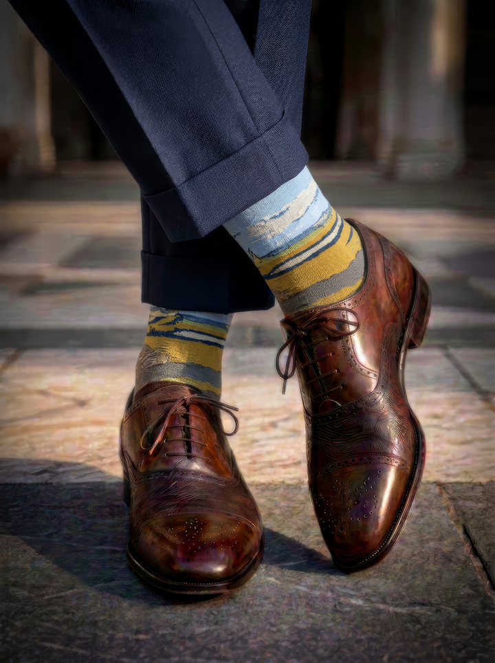 Fenced Field with Ploughman art socks by Vincent van Gogh worn with brown leather brogue Oxford shoes and navy trousers⠋