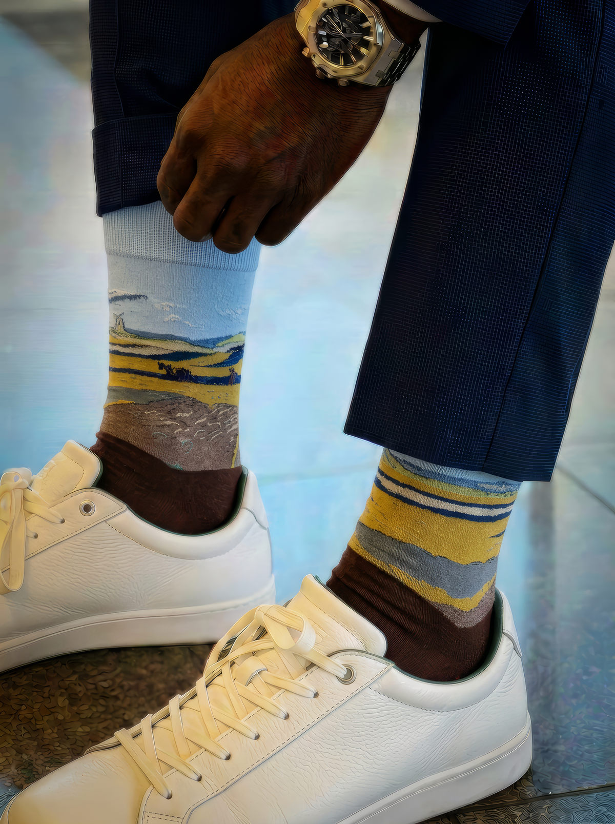Fenced Field with Ploughman art socks worn with white sneakers in a close-up lifestyle photo
