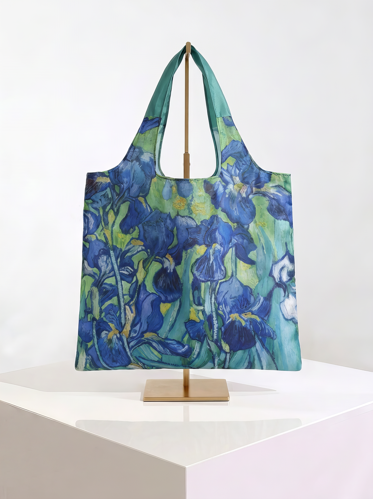 Foldable museum art shopper bag featuring Irises by Vincent van Gogh, displayed on a gold stand against a white museum-style background from ArtyGifts
