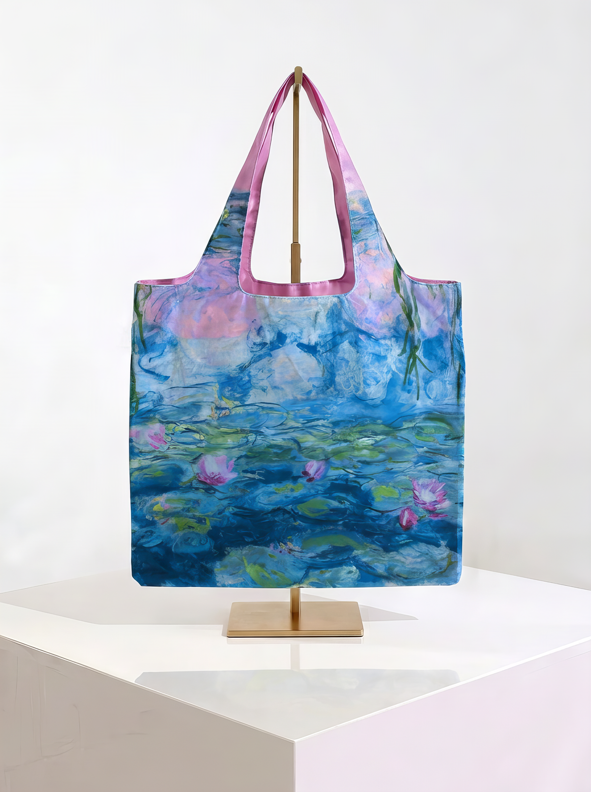 Foldable museum art shopper bag featuring Water Lilies by Claude Monet, displayed on a gold stand against a white museum-style background from ArtyGifts
