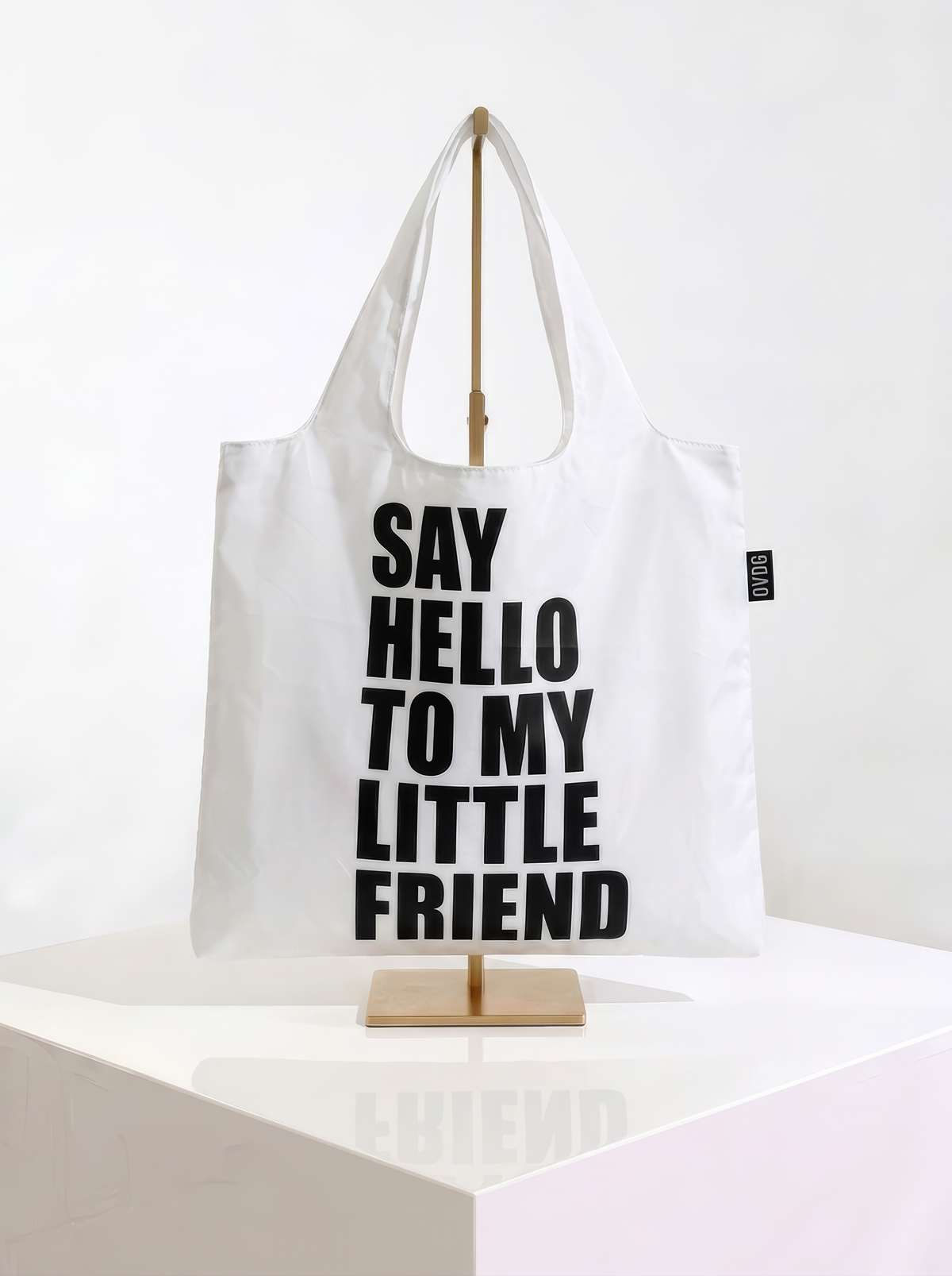 Back view of a foldable Scarface shopper bag featuring the text “Say Hello to My Little Friend”, displayed on a gold stand against a white background from ArtyGifts
