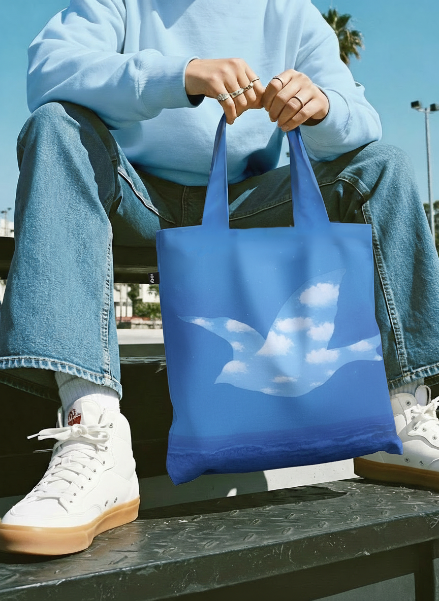 Foldable Shopper Bag The Promise René Magritte – woman carrying art bag on the street | ArtyGifts
