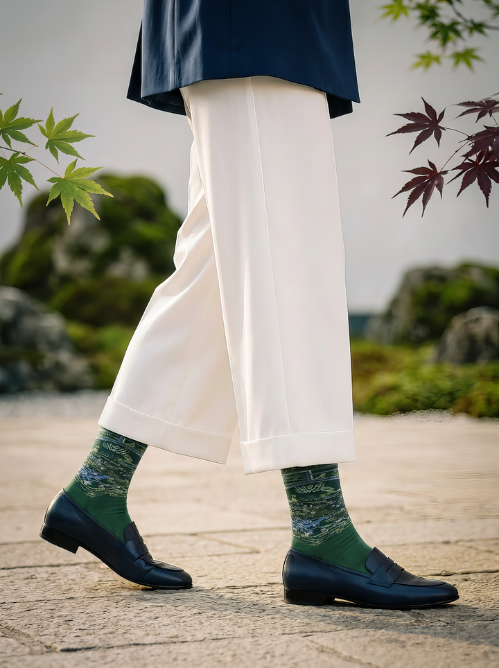 Person wearing green Claude Monet The Japanese Bridge art socks with white trousers and dark shoes while walking outdoors. Designed for women and men.