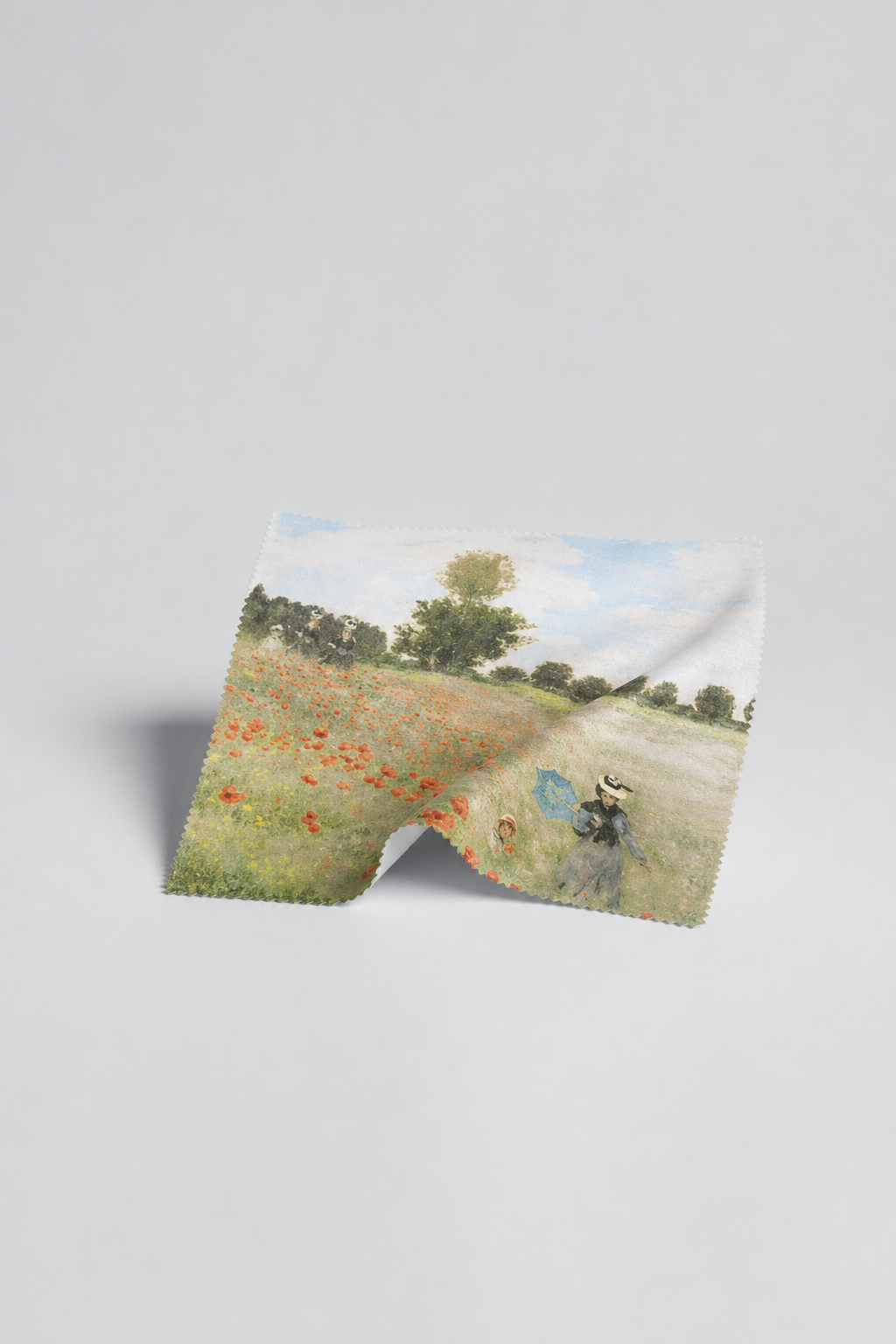 Microfiber lens cloth featuring Field with Poppies by Claude Monet, flat lay on white background
