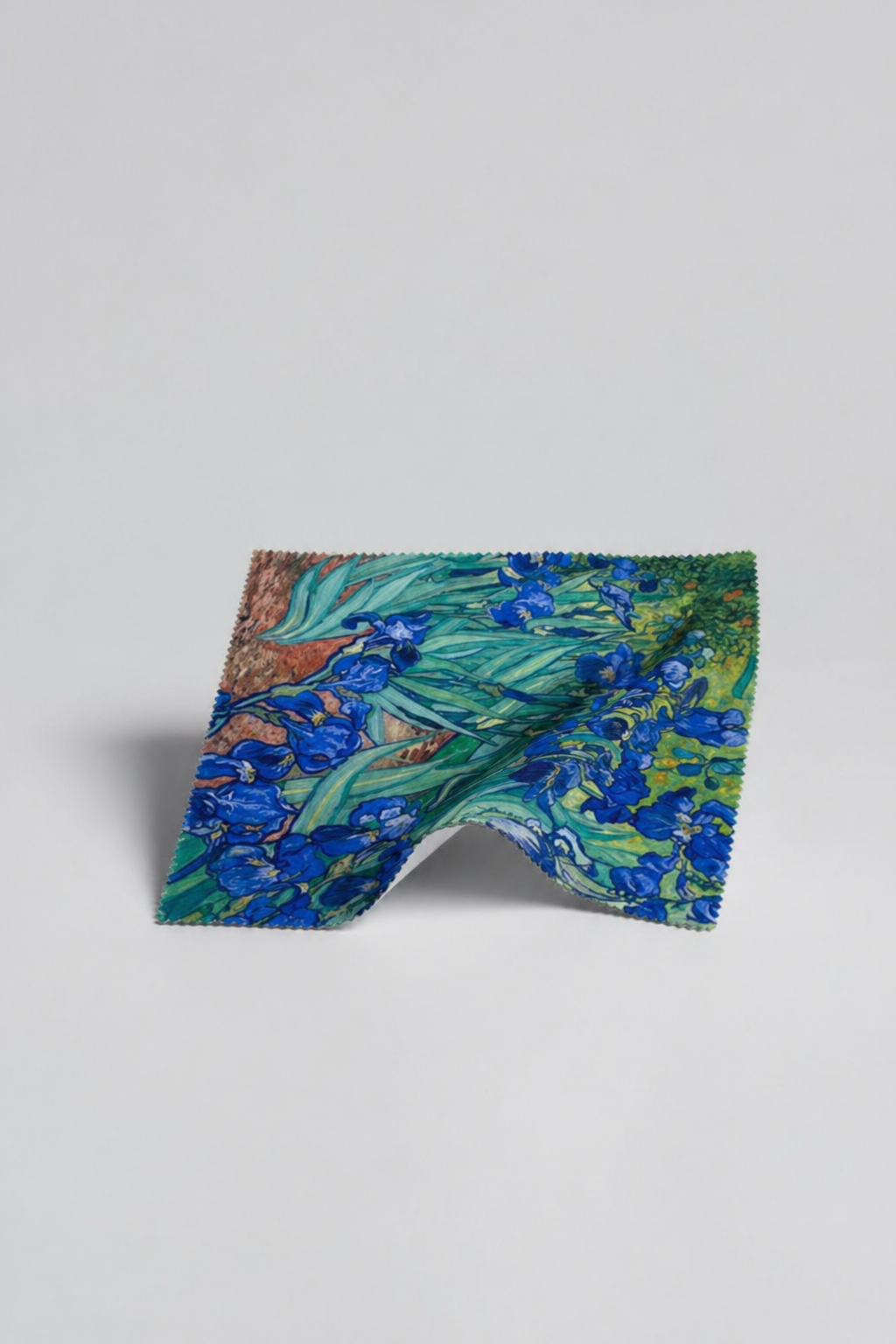 Microfiber lens cloth featuring Irises by Vincent van Gogh, flat lay on white background

