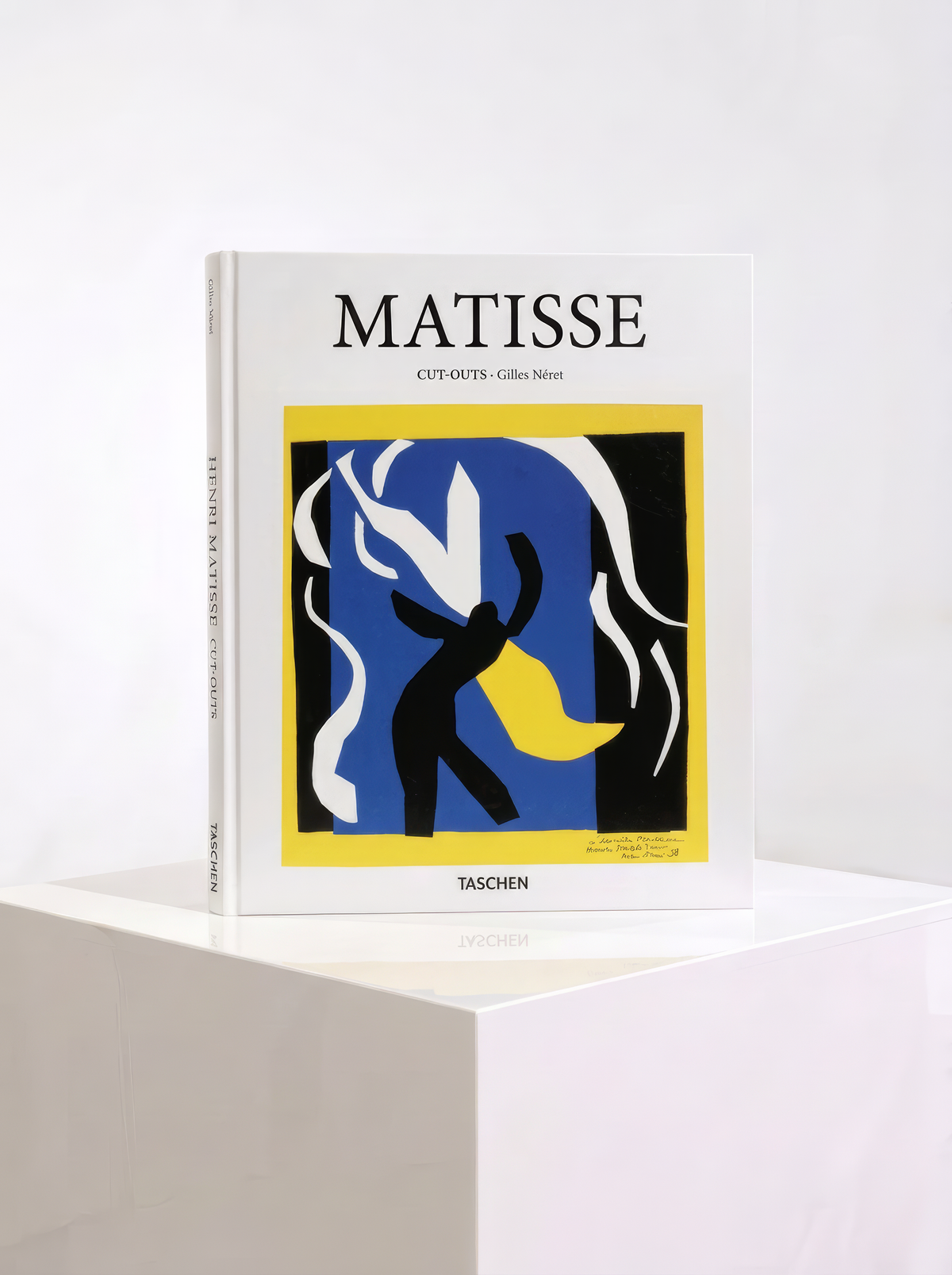 Open TASCHEN Matisse Cut-outs art book showing colourful leaf-like shapes in blue, green, red, yellow and black, with text on the left.
