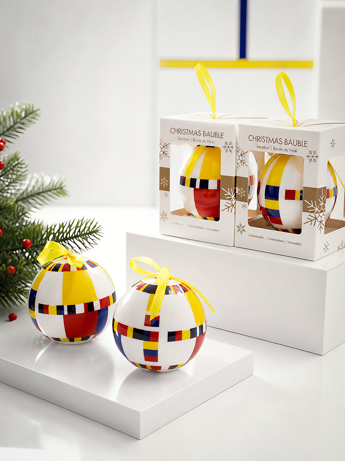 Mondrian Victory Boogie Woogie Christmas baubles with yellow ribbons and gift boxes on white background with pine branch – officially licensed museum art ornament from ArtyGifts