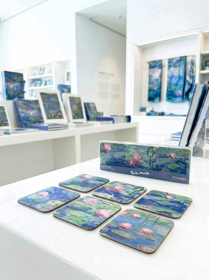 Monet Water Lilies cork coasters on museum table with gift box — museum art gift | ArtyGifts
