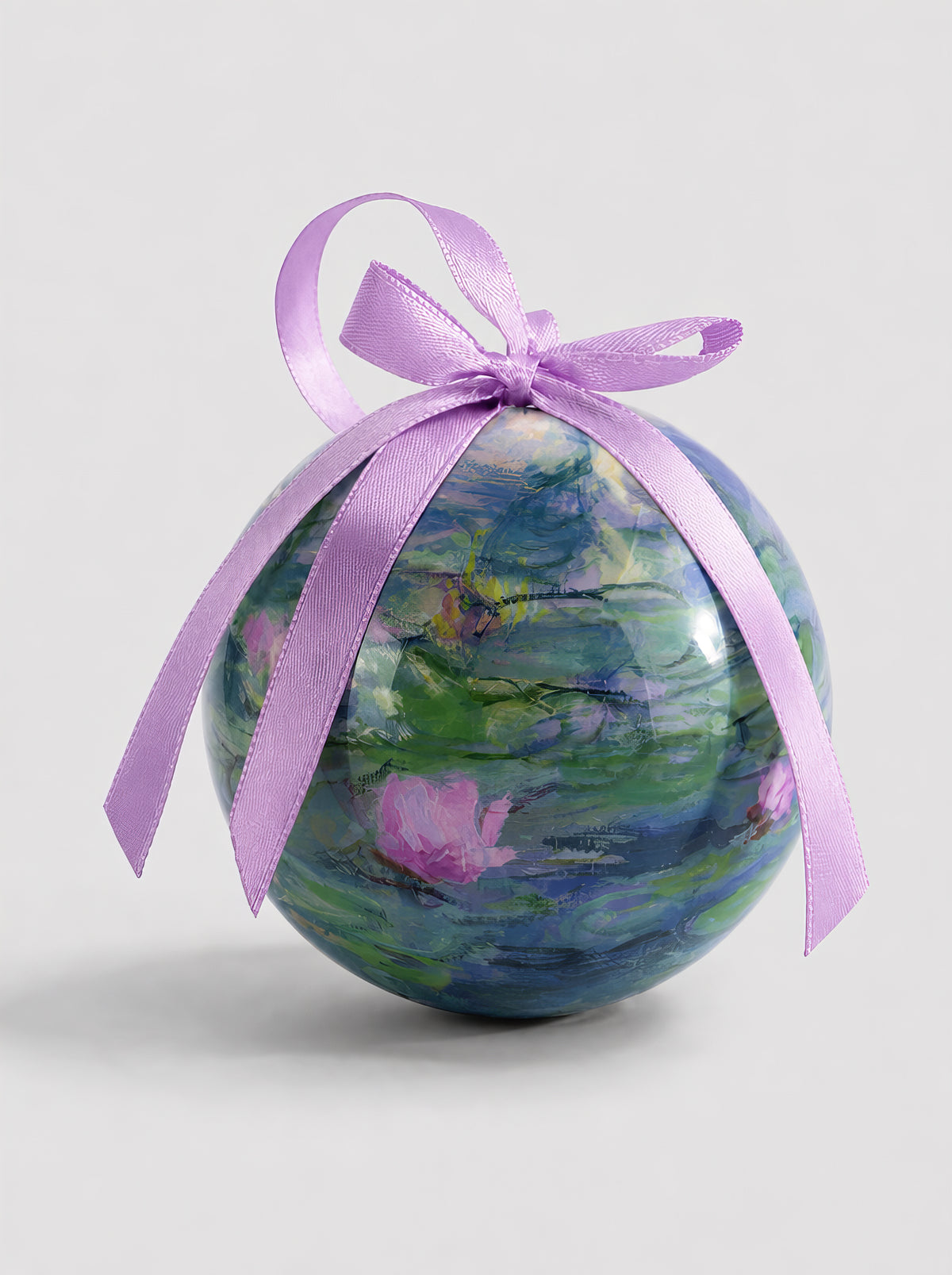 Monet Water Lilies Christmas bauble close-up on grey background with purple ribbon – officially licensed museum art ornament from ArtyGifts
