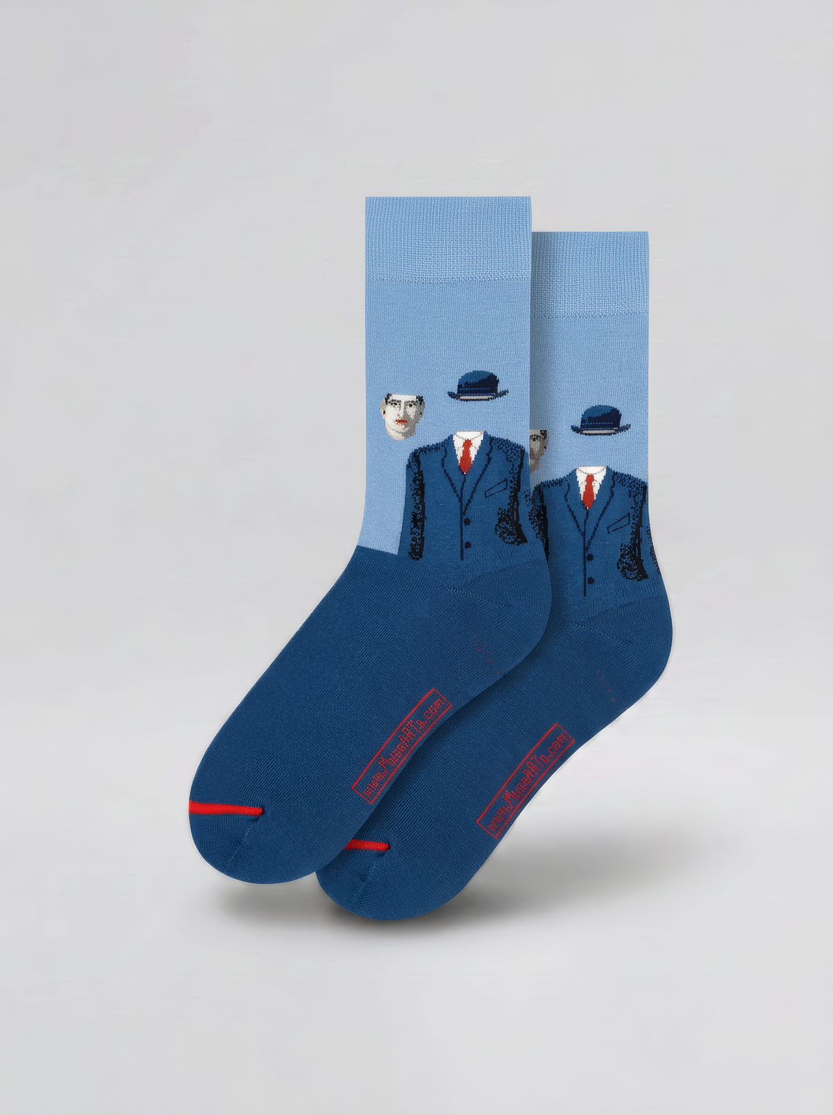 Pair of blue art socks with pale blue cuffs and figures wearing dark suits and bowler hats, displayed against a light grey background.
