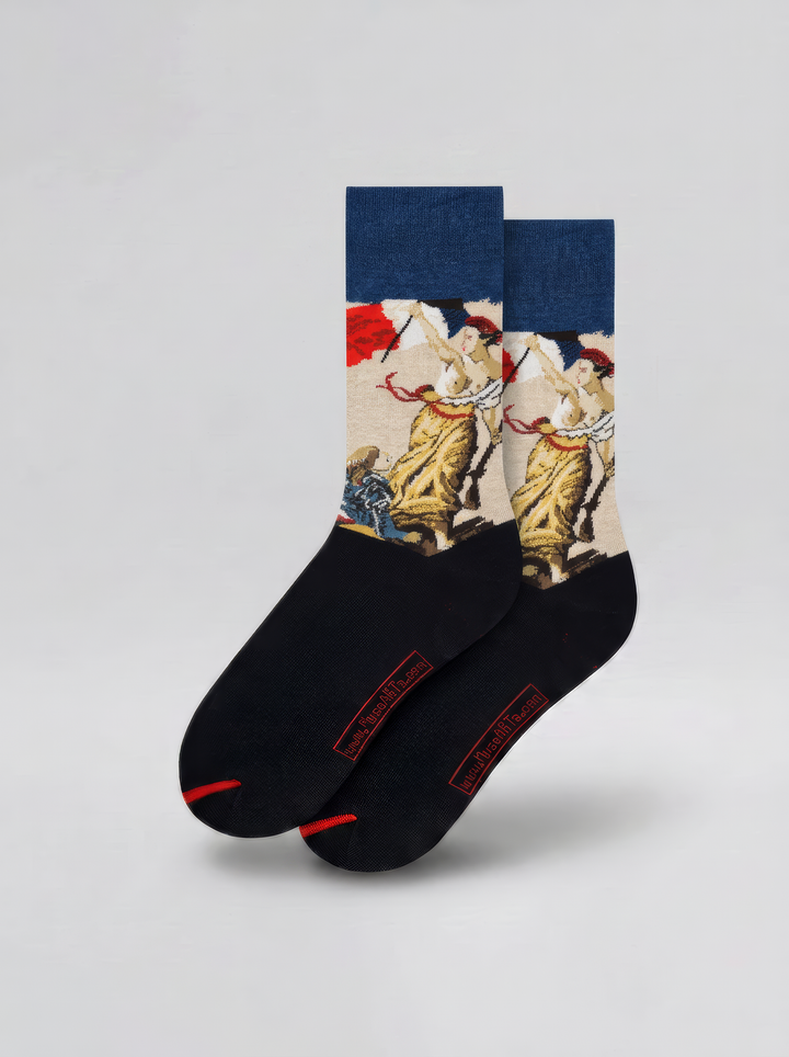 Pair of art socks with navy cuffs, cream illustrated panels and black feet, displayed upright against a pale grey background.
