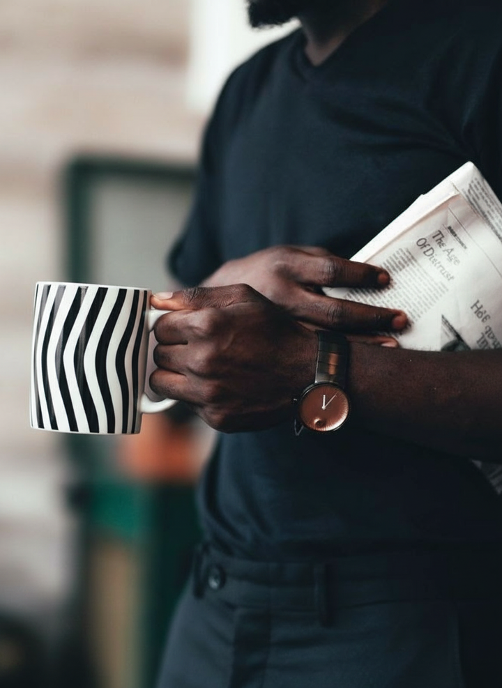 Optical Art porcelain mug – person holding black and white striped mug, ArtyGifts