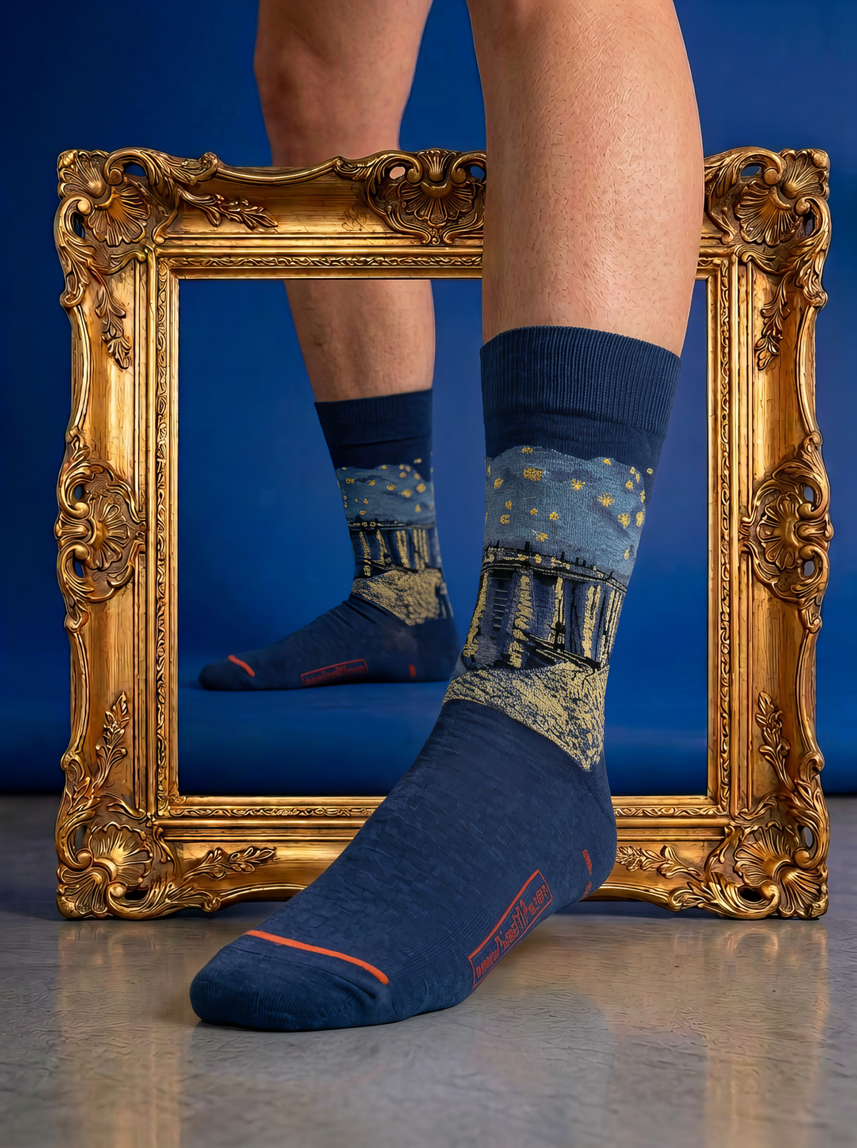 Starry Night over the Rhône art socks styled in front of an ornate gold frame