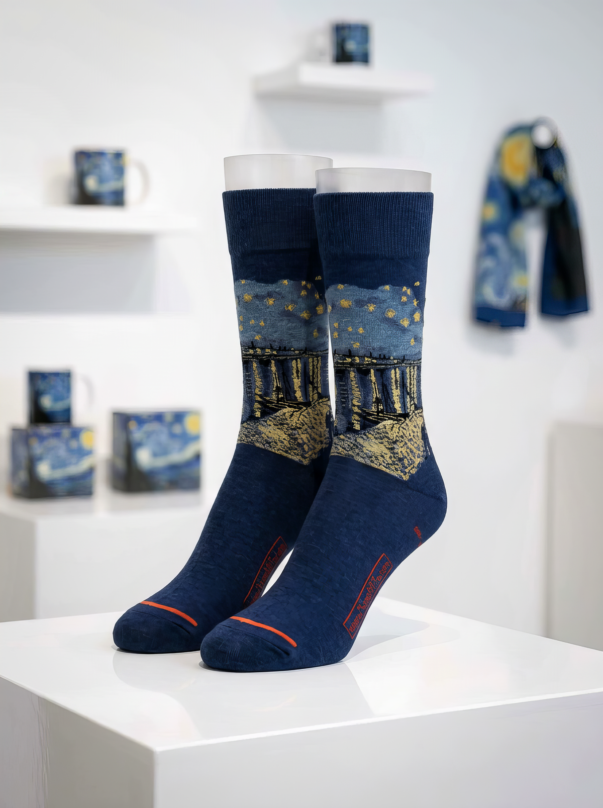 Starry Night over the Rhône art socks by Vincent van Gogh displayed on a white pedestal in a gallery-style interior