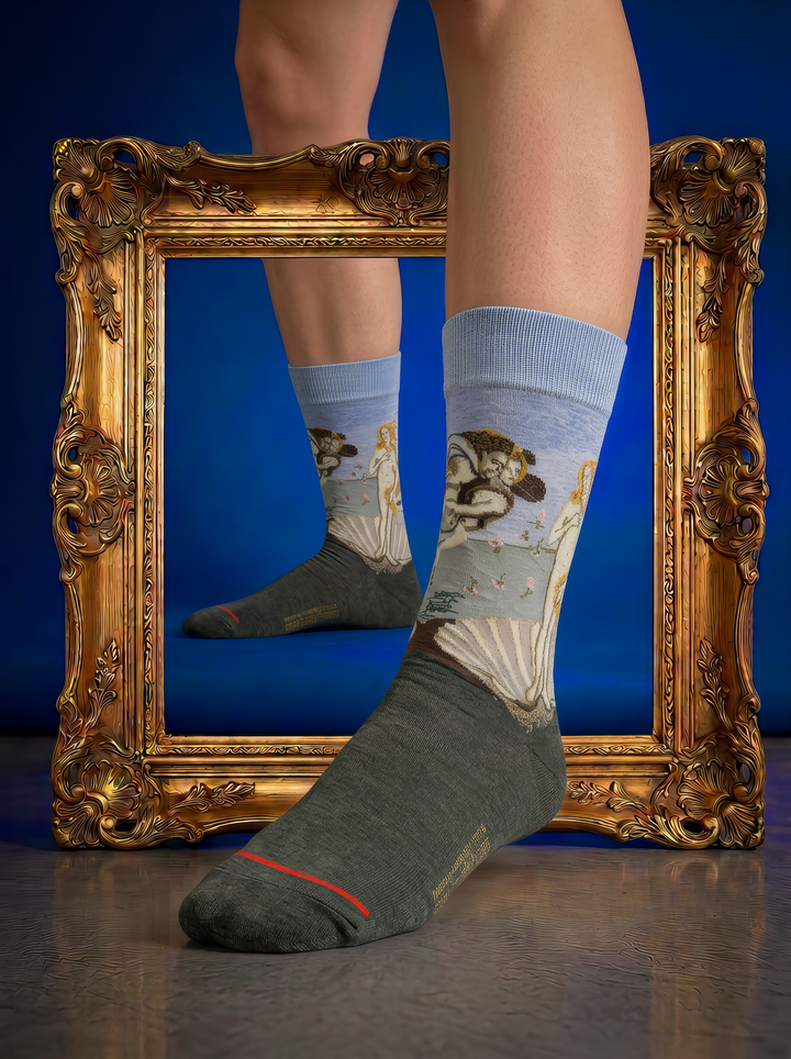 The Birth of Venus art socks featuring Botticelli’s artwork shown in front of an ornate gold frame