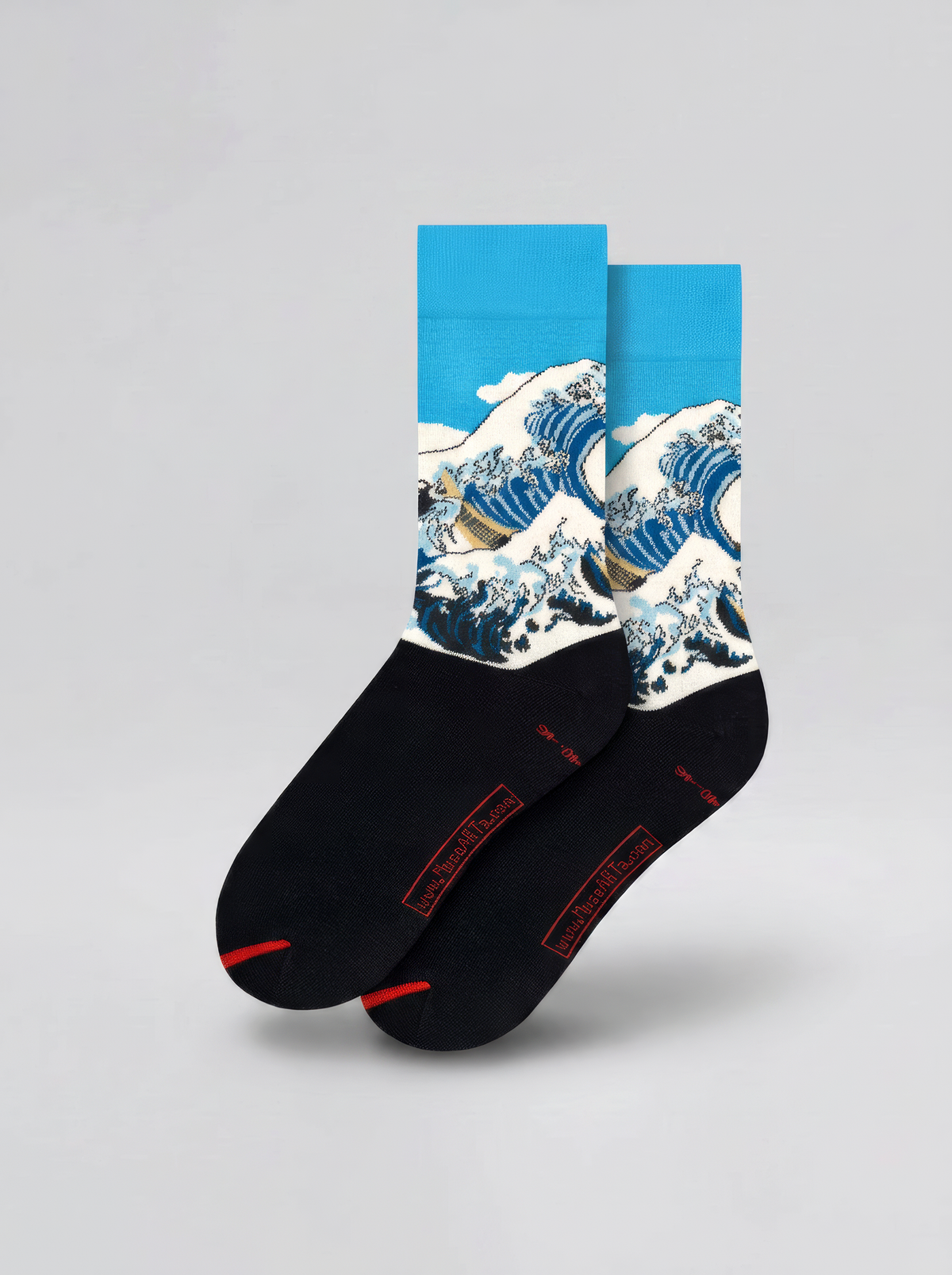 Pair of black and blue The Great Wave art socks by Katsushika Hokusai shown on a white background