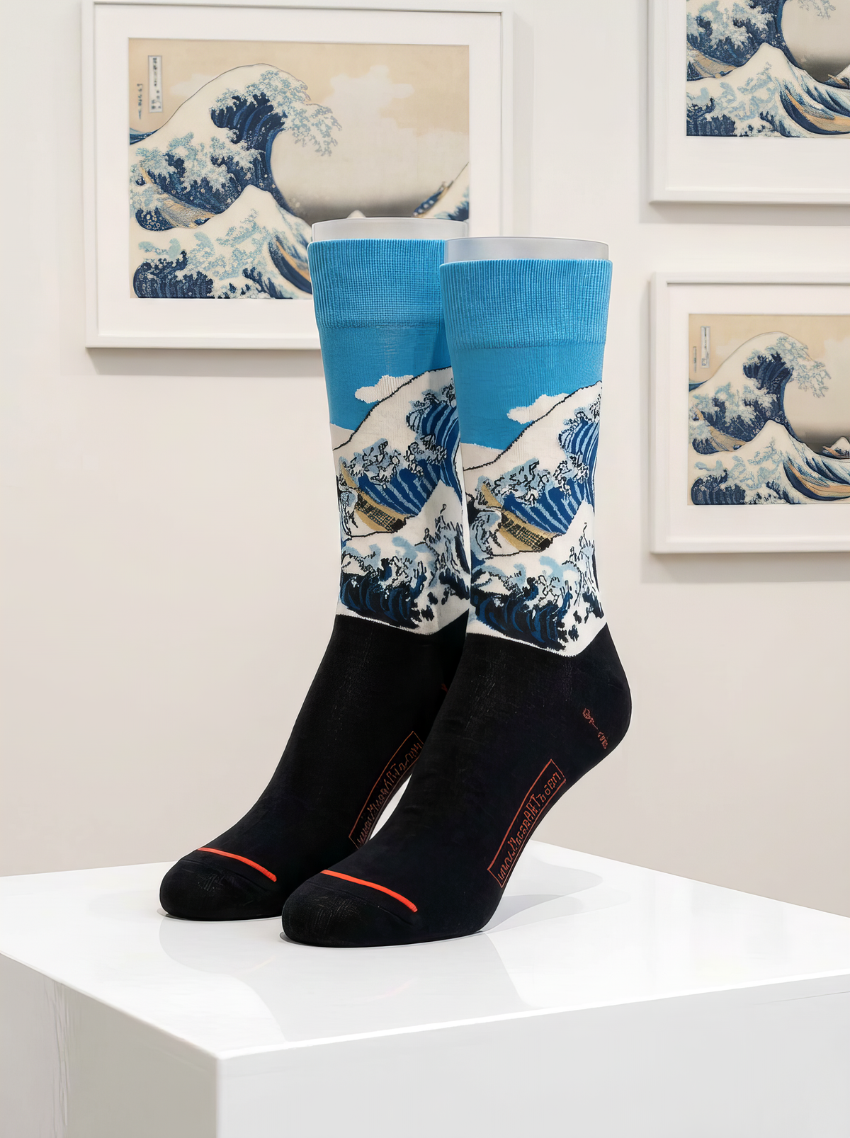 Black and blue The Great Wave art socks by Katsushika Hokusai displayed on a white pedestal