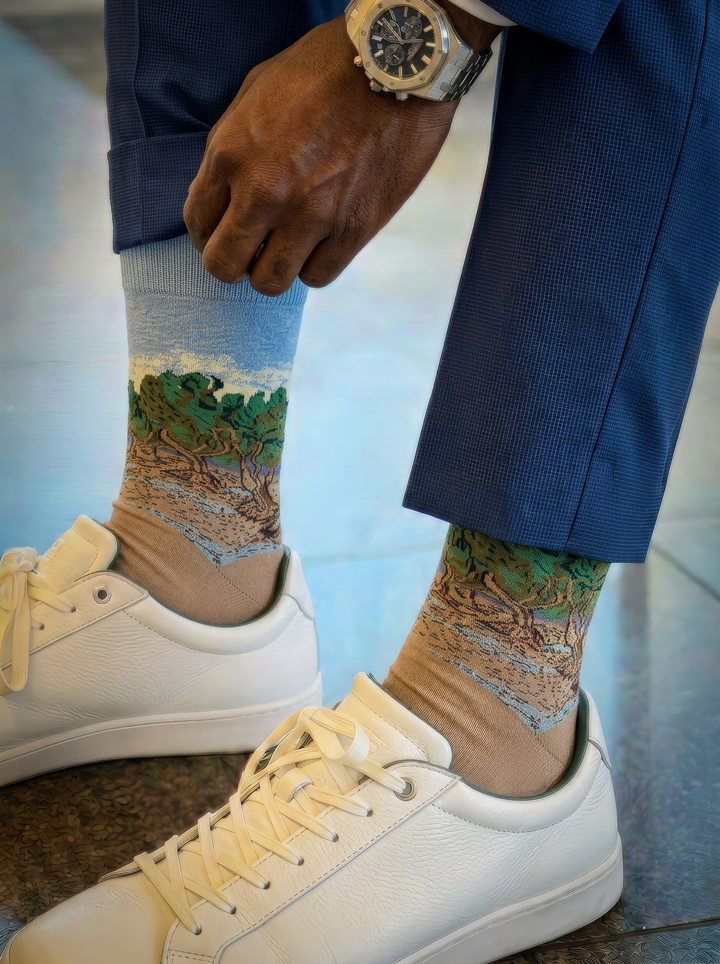 The Olive Trees art socks by Vincent van Gogh worn with white lace-up sneakers and navy trousers