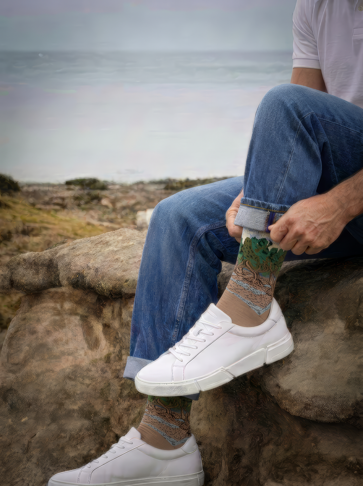 The Olive Trees art socks by Vincent van Gogh worn with white sneakers beside the coast