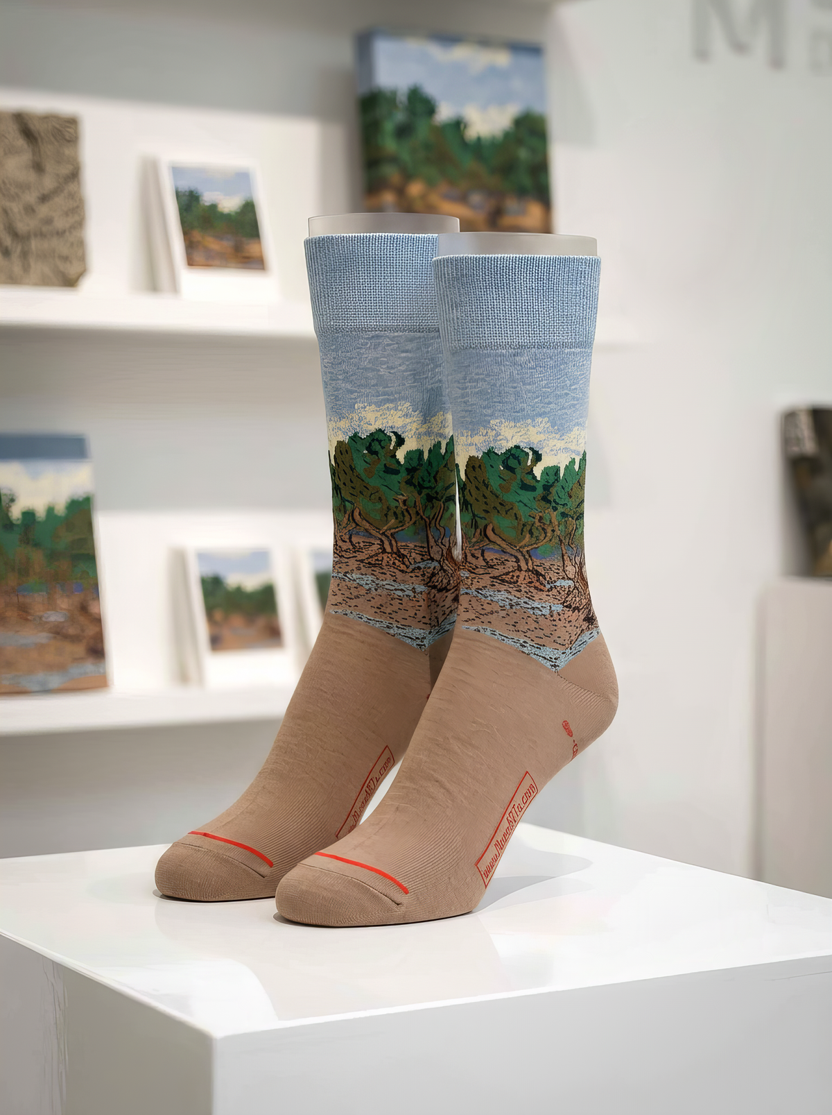 The Olive Trees unisex art socks by Vincent van Gogh displayed on a white pedestal
