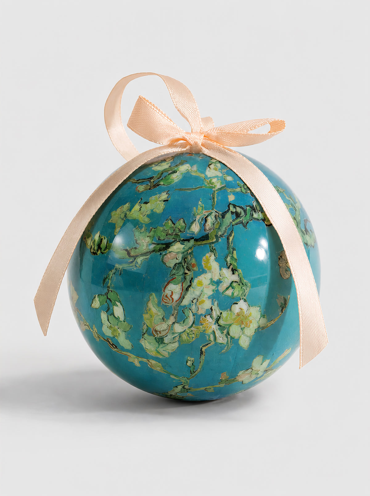 Close-up of a Vincent van Gogh Almond Blossom Christmas bauble with cream ribbon on a light grey background, showing white blossoms and branches on turquoise blue – officially licensed museum art ornament, 7 cm diameter, unbreakable, in gift box. A unique Dutch Post-Impressionist art Christmas gift from ArtyGifts