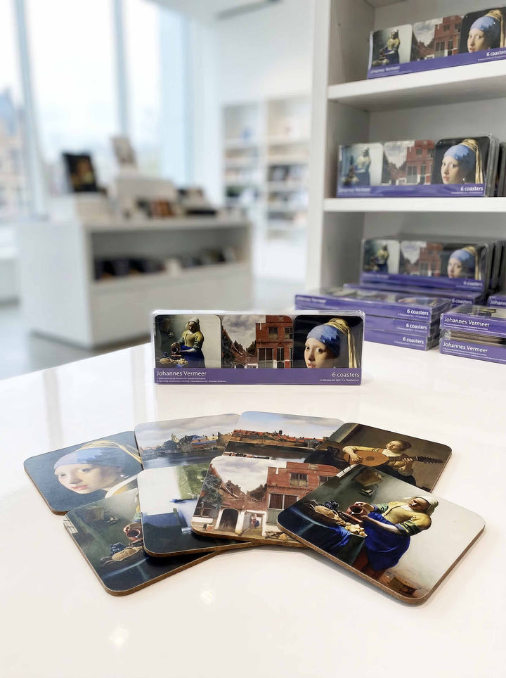 Vermeer Masterpieces cork coasters fanned out on museum table — museum art gift | ArtyGifts