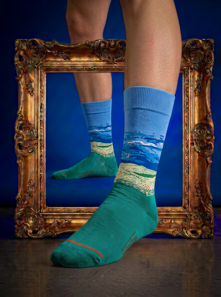 Wheat Field under Thunderstorm Sky art socks styled without shoes in front of an ornate gold frame