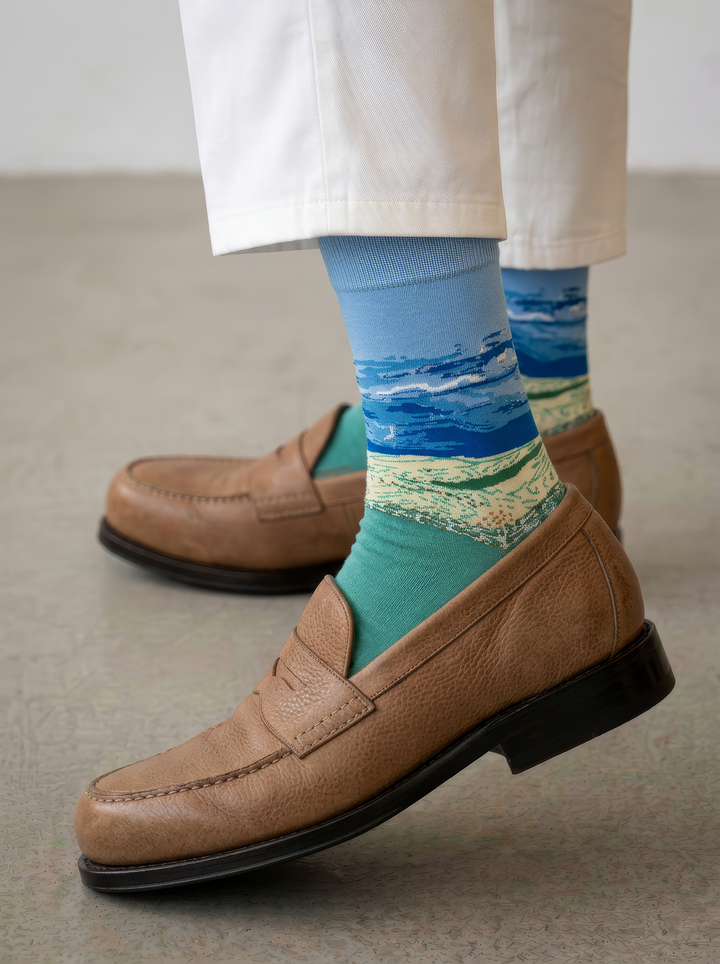 Wheat Field under Thunderstorm Sky unisex art socks by Vincent van Gogh worn with tan leather penny loafers and white trousers