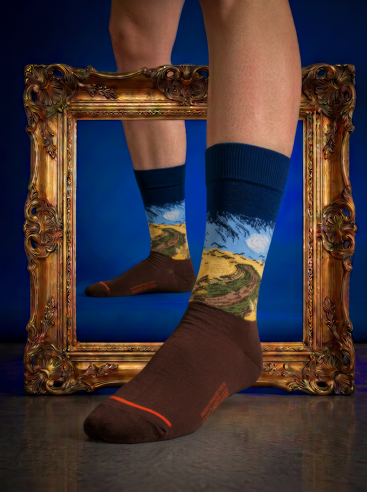 Wheatfield with Crows art socks styled in front of an ornate gold frame


