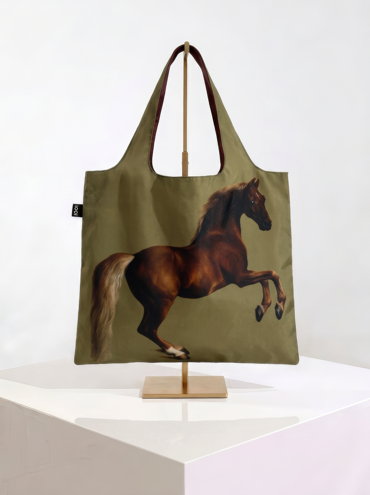 Olive-green foldable shopper bag featuring George Stubbs’s Whistlejacket horse painting, displayed on a stand against a white background.
