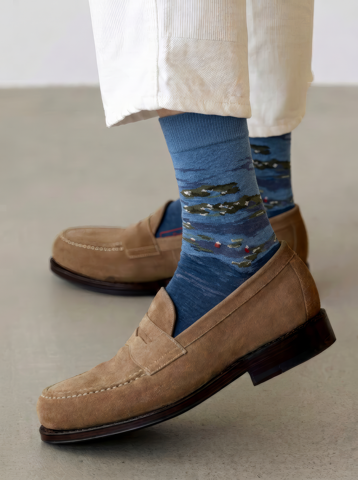 Pair of blue XL socks featuring Claude Monet’s Water Lilies by Evening Light, styled with cream trousers and tan suede loafers.