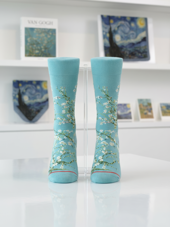 Van Gogh Almond Blossom art socks on display stand in museum setting with Starry Night and other Van Gogh artworks in background — ArtyGifts