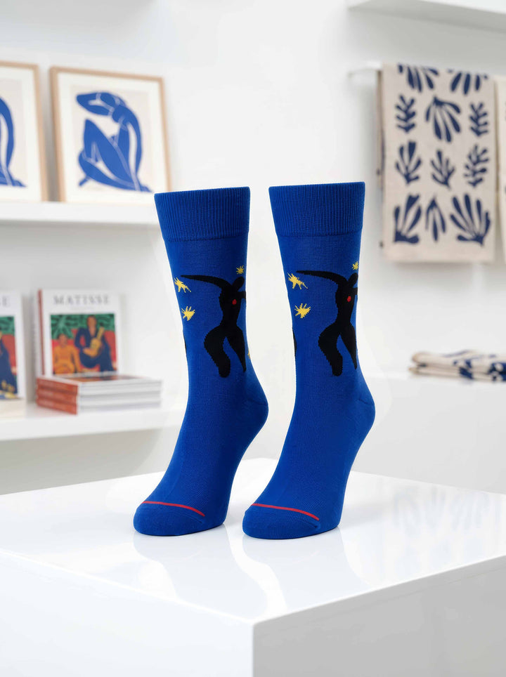 Matisse Icarus art socks on display in museum setting with Henri Matisse artworks in background — ArtyGifts