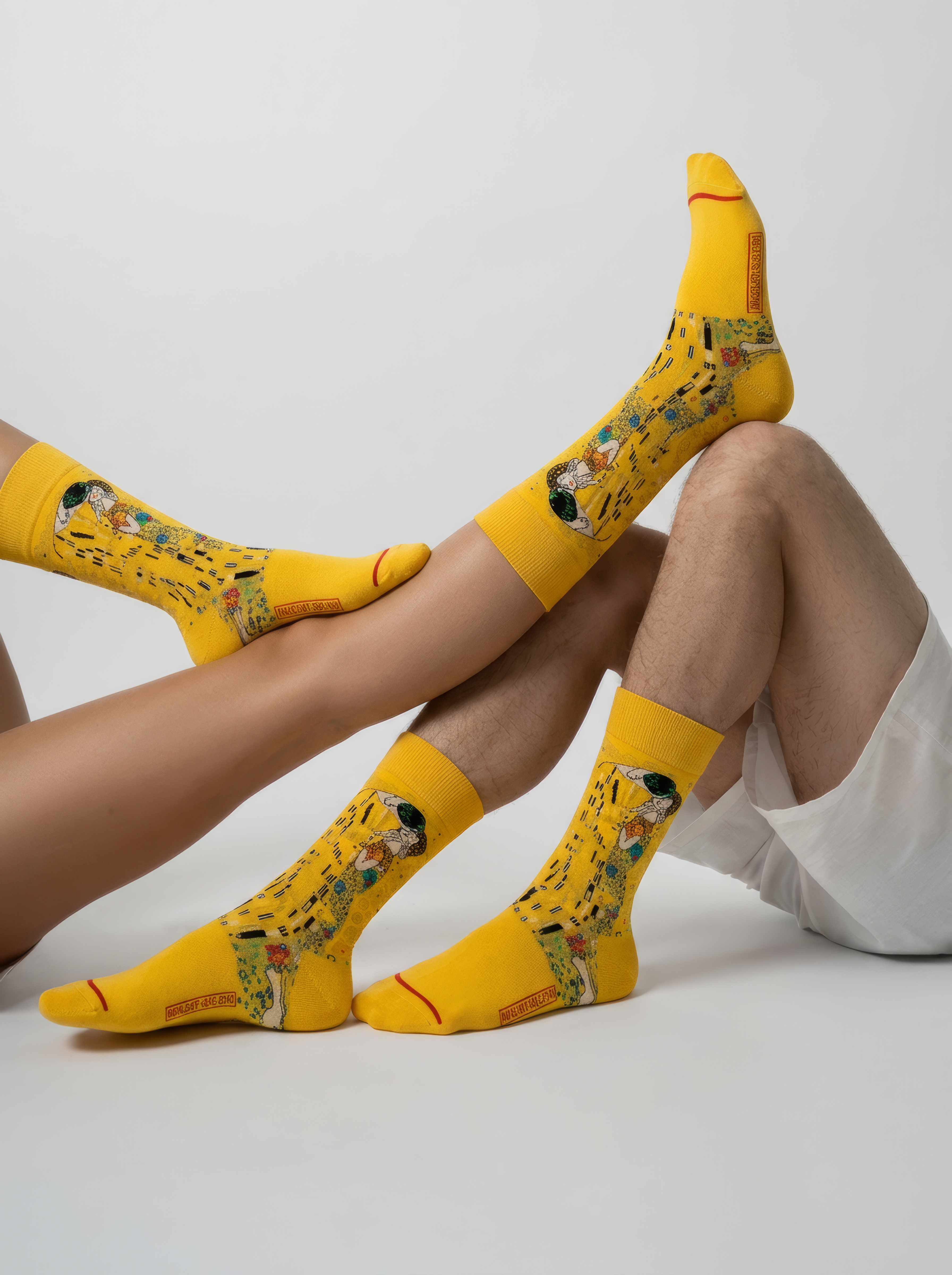 Unisex MuseARTa Klimt The Kiss art socks worn by man and woman lying down — diverse Art Nouveau gift ArtyGifts
