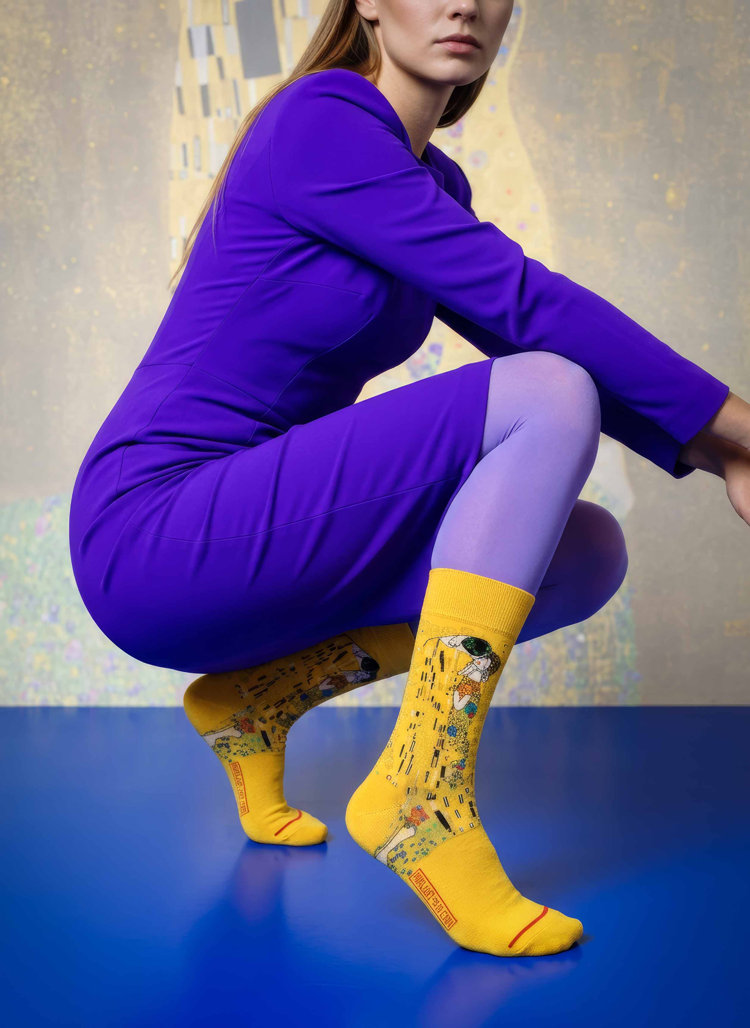 Woman in purple outfit wearing MuseARTa Klimt The Kiss art socks crouching — Art Nouveau Belvedere Vienna gift ArtyGifts
