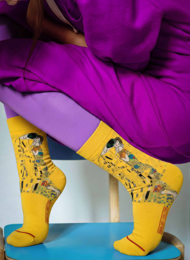 Woman in purple sitting wearing MuseARTa Klimt The Kiss art socks — Art Nouveau Belvedere Vienna gift ArtyGifts
