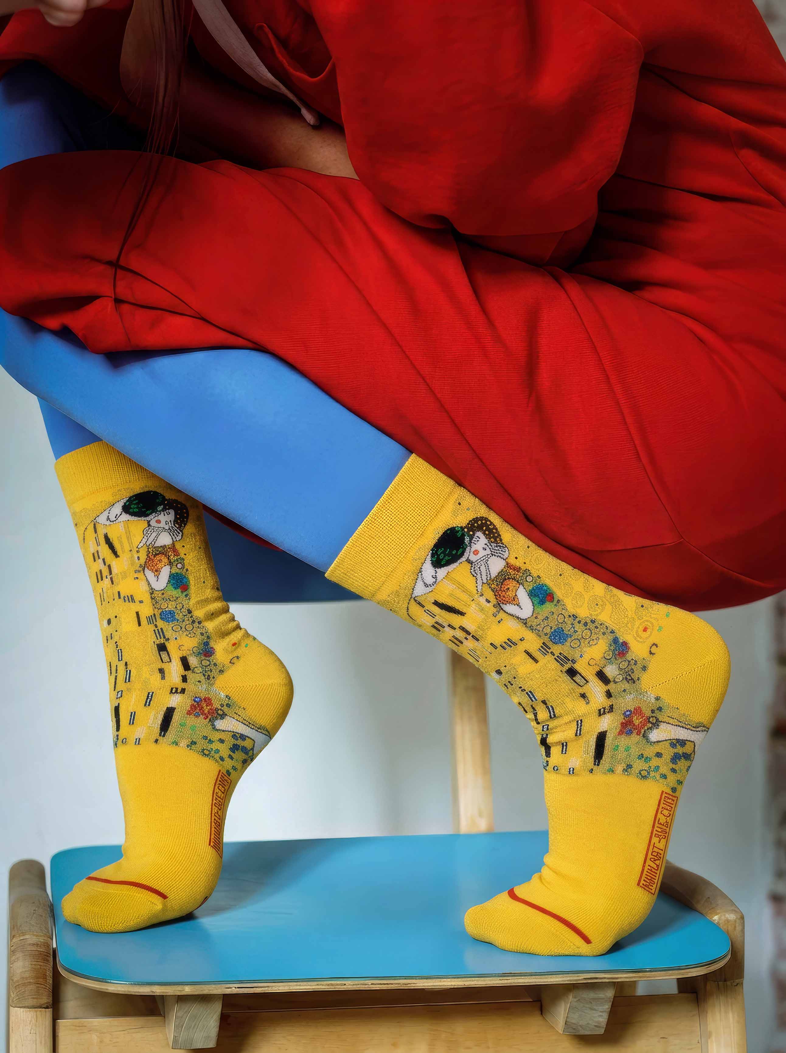 Woman wearing MuseARTa Klimt The Kiss art socks with red jacket — elegant Art Nouveau museum gift ArtyGifts
