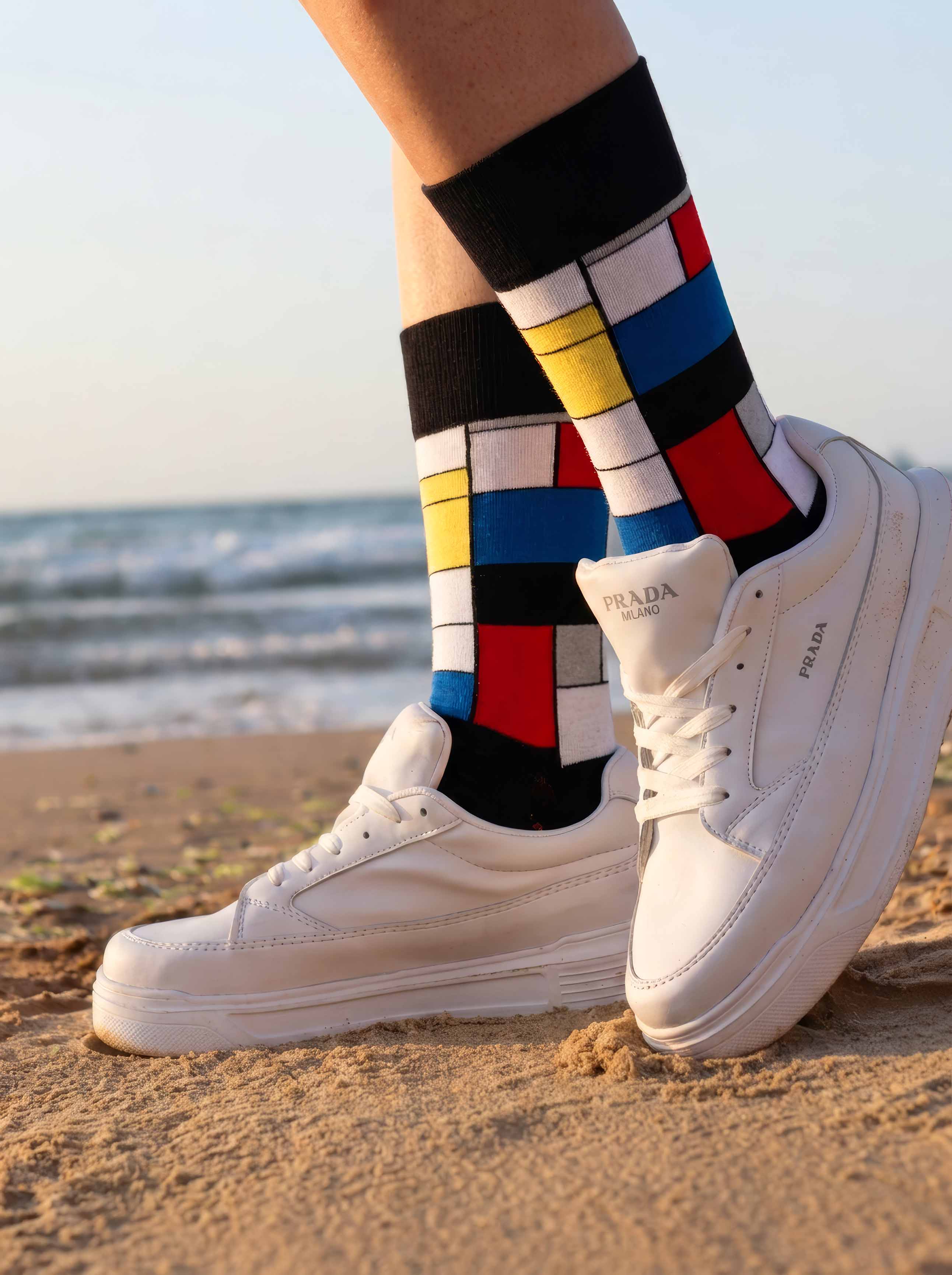 MuseARTa Mondrian art socks worn with white sneakers on the beach — unisex art gift ArtyGifts