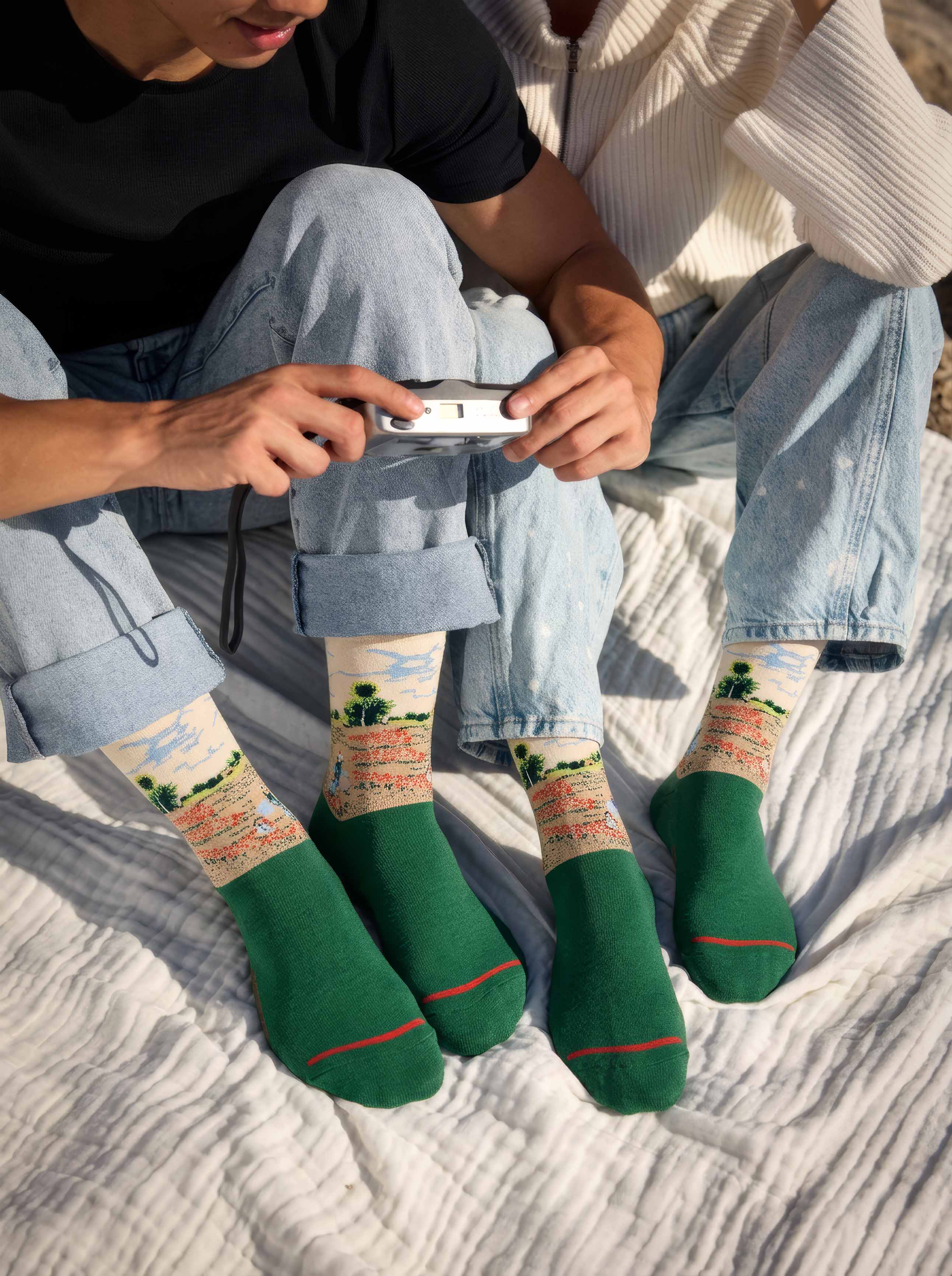 Unisex couple wearing MuseARTa Monet Field of Poppies art socks together — diverse Impressionist museum gift ArtyGifts
